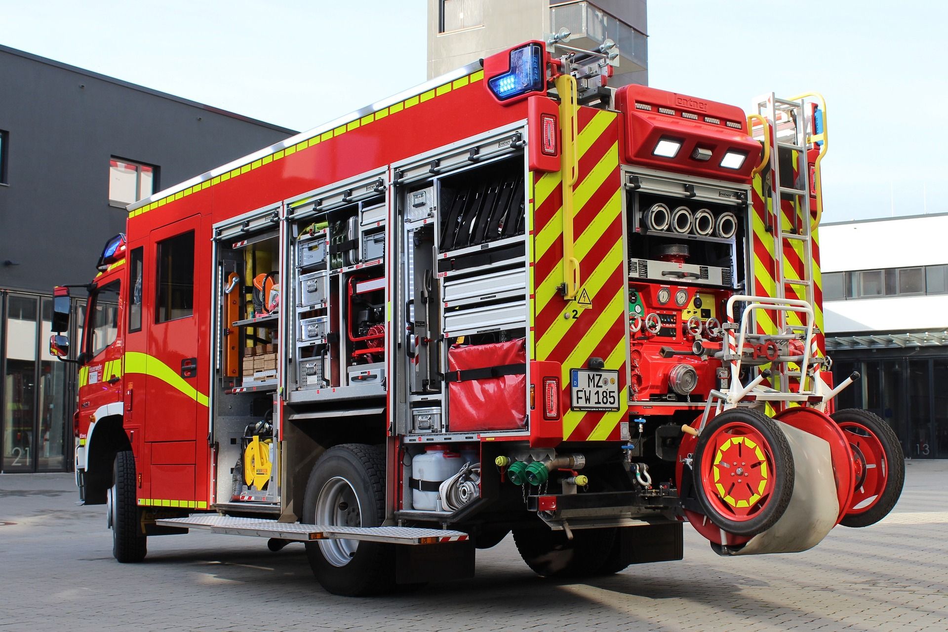 Feuerwehrfahrzeug mit geöffneten Geräteräumen und verlasteter Ausrüstung.